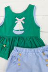 a green dress with a sailboat applique on it