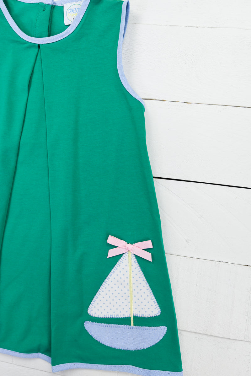 a green dress with a sailboat applique on it