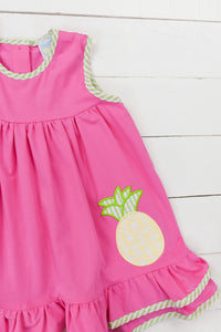 a pink dress with a pineapple applique on it