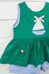 a green dress with a sailboat applique on it